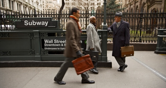 Businessmen Walking Past Wall Street Station