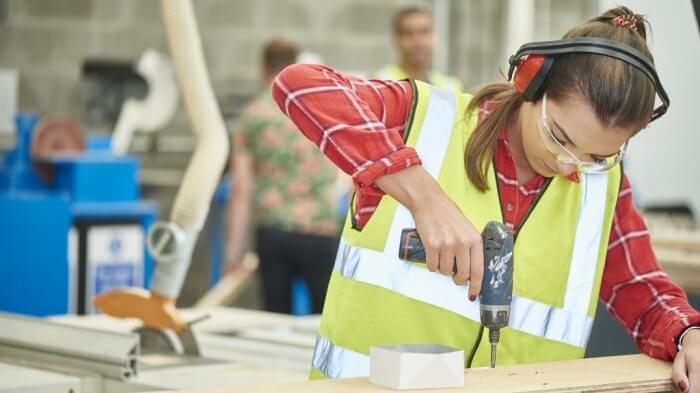 female carpenter screwing her work together
